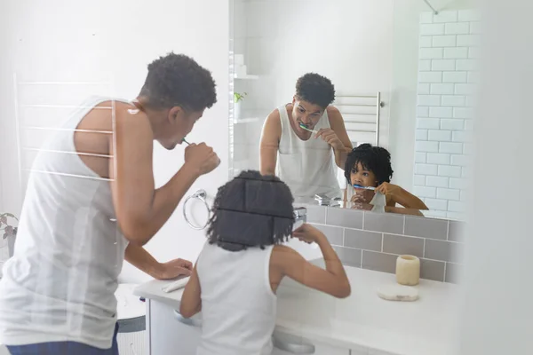 浴室の鏡の前で一緒にヒスパニック系の父と息子の歯をブラッシング 変化のない家族団結衛生ルーチンの概念 — ストック写真