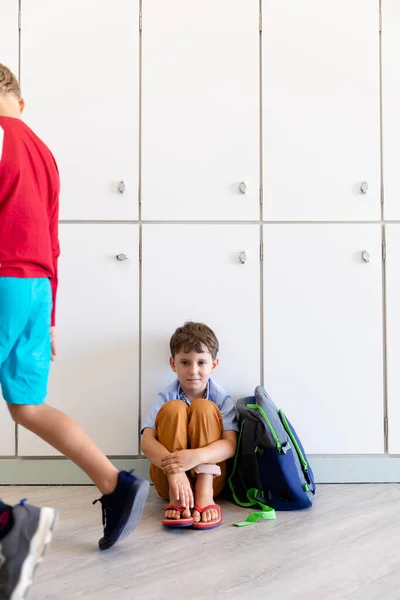 Volledige Lengte Van Kaukasische Elementaire Schooljongen Knuffelen Knieën Terwijl Zitten — Stockfoto