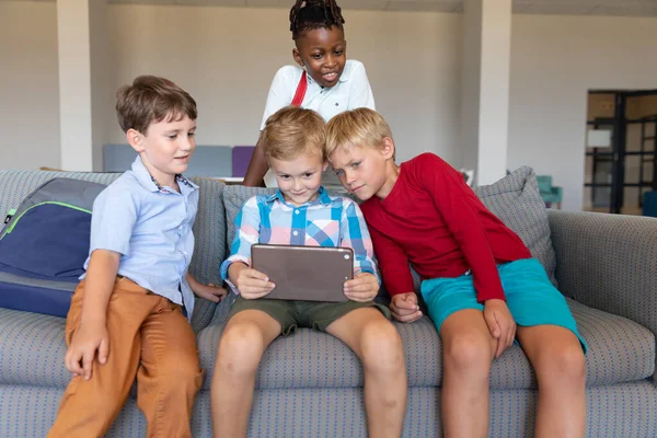 Multiraciale Basisschooljongens Kijken Naar Digitale Tablet Terwijl School Bank Zitten — Stockfoto