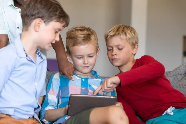 Multiraciale Basisschooljongens Die Digitale Tablet Gebruiken Terwijl Bank School Zitten — Stockfoto