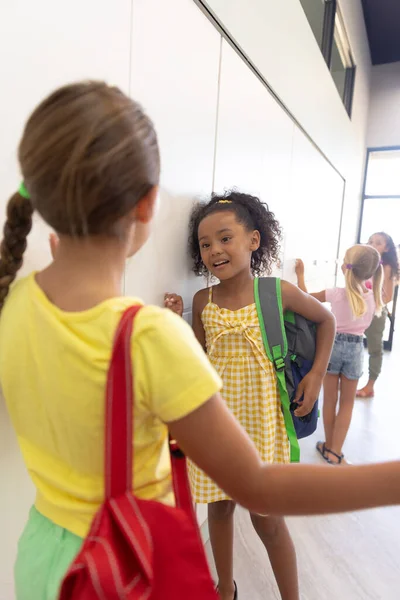 Multiracial Elementary Schoolgirls Talking While Standing Lockers School Corridor Unaltered — Stock Photo, Image