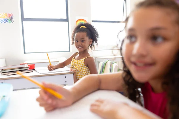 Retrato Niña Birracial Feliz Escribiendo Libro Mientras Está Sentado Escritorio —  Fotos de Stock