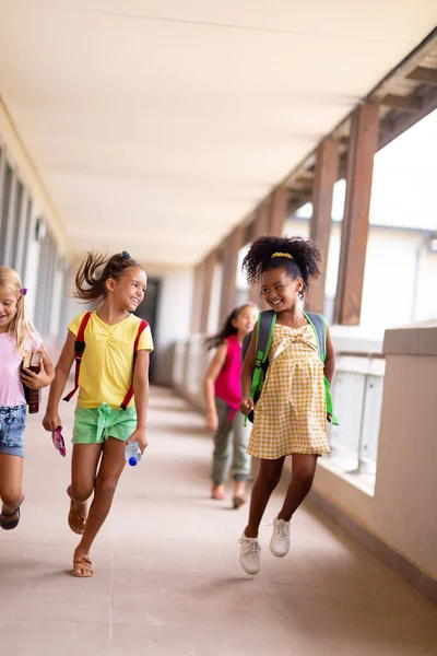 Full Length Cheerful Multiracial Elementary Schoolgirls Walking Corridor Unaltered Childhood — Stock Photo, Image