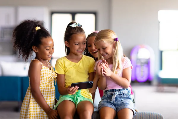 快乐的多种族小学女生在学校看智能手机 无线技术 教育和重返校园的概念 — 图库照片