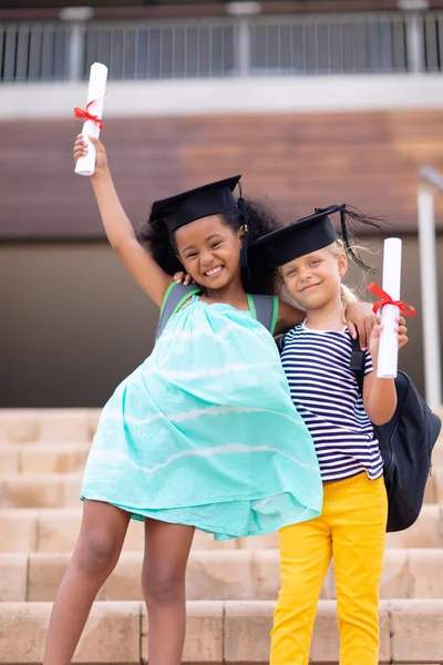 Portrait Happy Multiracial Elementary Schoolgirls Mortarboard Degree Standing Steps Unaltered — Stock Photo, Image