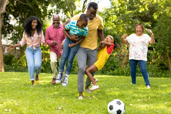 快乐的非洲裔美国家庭在后院一起踢足球 不变的家庭 周末和闲暇的概念 — 图库照片