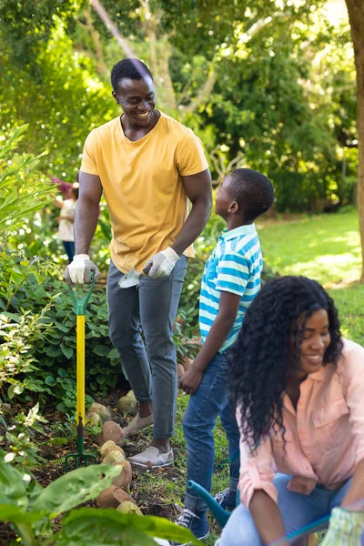 週末には裏庭で父親と母親とアフリカ系アメリカ人の少年園芸を笑っています 変わらない家族一緒に週末趣味自然園芸の概念 — ストック写真