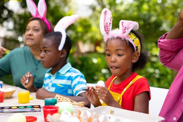African American Girl Wearing Bunny Ears Painting Eggs Family Backyard — Stock Photo, Image