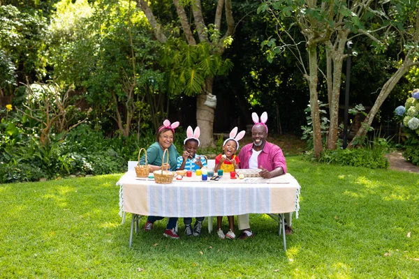 Šťastní Afroameričtí Sourozenci Prarodiče Králičích Uších Malují Dvorku Velikonoční Vajíčka — Stock fotografie