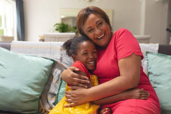 Mujer Mayor Afroamericana Feliz Abrazando Nieta Sofá Casa Inalterado Estilo —  Fotos de Stock