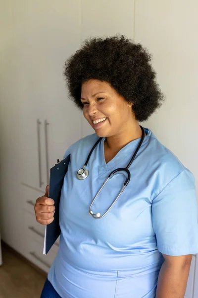 Χαμογελώντας Αφροαμερικανή Μεσήλικη Νοσοκόμα Στηθοσκόπιο Και Πρόχειρο Στο Νοσοκομείο Αναλλοίωτος — Φωτογραφία Αρχείου