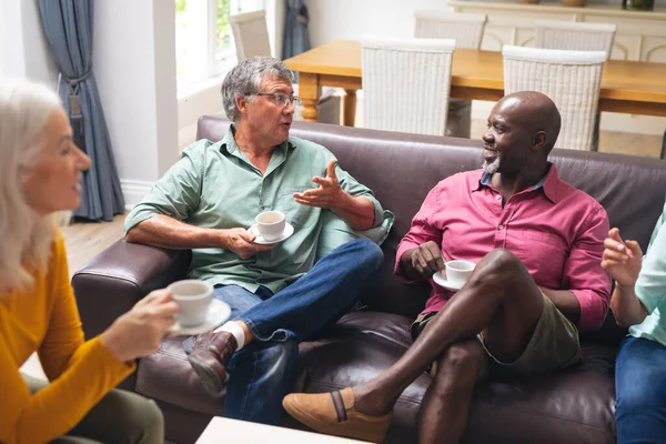 多种族的高级男女朋友一边聊天一边在家里喝咖啡 不变的生活方式 社交聚会 聚会和休闲 — 图库照片