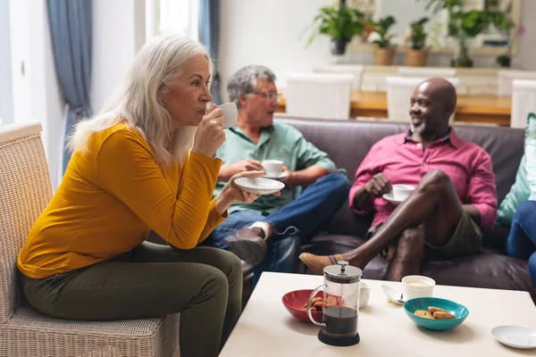 老年妇女在家里边喝咖啡边和多种族朋友聊天 不变的生活方式 社交聚会 聚会和休闲 — 图库照片