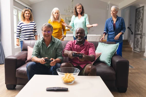 Glad Multiracial Senior Manliga Vänner Spelar Spel Medan Kvinnor Bakgrunden — Stockfoto