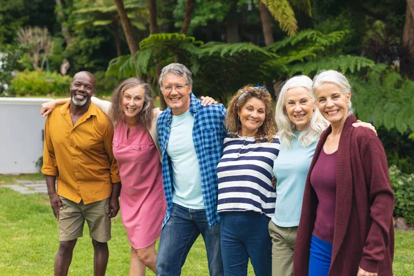 多种族快乐的老年男女朋友抱着胳膊站在后院的画像 生活方式 聚会和活跃的老年人 — 图库照片