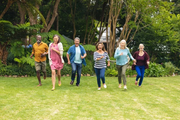无忧无虑的多种族老年男女朋友在后院奔跑 生活方式 快乐和活跃的老年人 — 图库照片