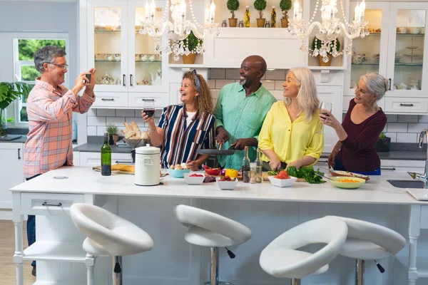 Homem Sênior Fotografando Felizes Amigos Multirraciais Masculinos Femininos Preparando Comida — Fotografia de Stock