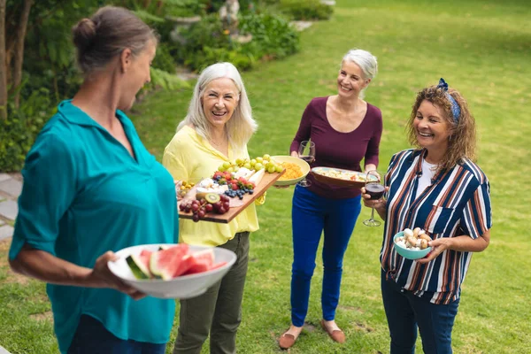 Gelukkige Blanke Oudere Vrouwelijke Vrienden Die Eten Dragen Achtertuin Tijdens — Stockfoto