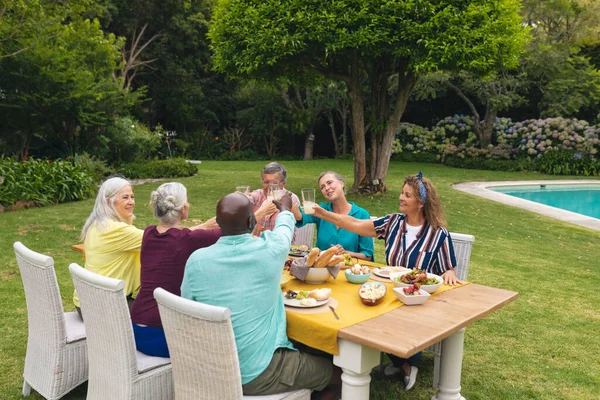 Multiraciale Oudere Mannelijke Vrouwelijke Vrienden Toasten Wijn Aan Tafel Tijdens — Stockfoto