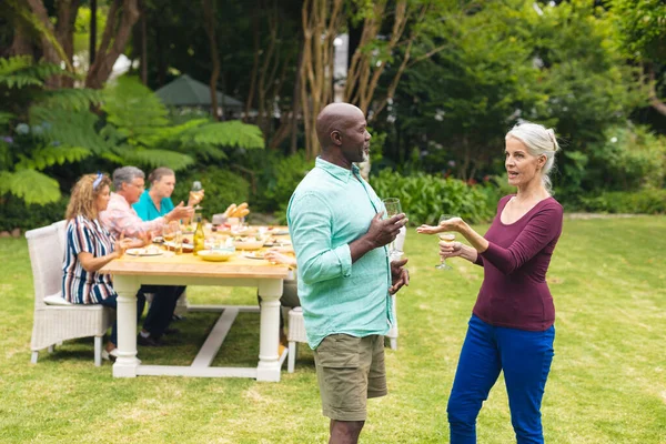 Multiracial Senior Vänner Prata Och Vin Medan Vänner Bakgrunden Bakgård — Stockfoto