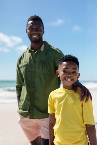 在阳光灿烂的日子里 非洲裔美国男孩和父亲站在沙滩上的画像 不变的家庭 生活方式 享乐及假日概念 — 图库照片