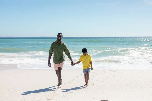 空に向かってビーチを歩いている間 幸せなアフリカ系アメリカ人男性の完全な長さ 変わることのない家族生活一緒に楽しむ休日の概念 — ストック写真