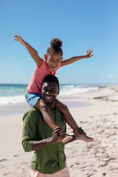 Веселая Африканская Американка Протянутыми Руками Сидящая Плечах Отца Пляже Неизменная — стоковое фото