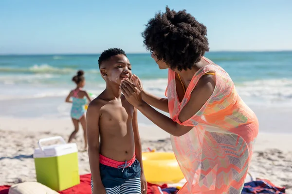 Африканська Американка Застосовує Сонячні Лосьйони Щоках Сина Пляжі Сонячний День — стокове фото