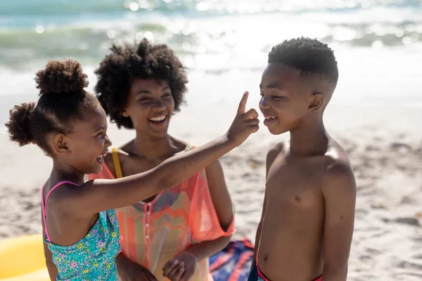 Wesoła Afrykańska Dziewczyna Nakładająca Balsam Opalania Nos Brata Plaży Bez — Zdjęcie stockowe