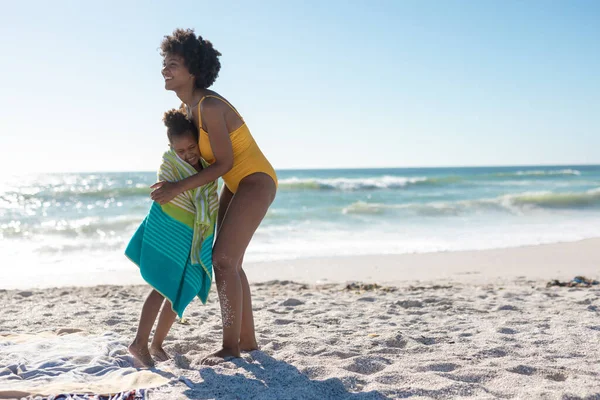 Ragazza Afroamericana Avvolto Asciugamano Abbracciando Madre Felice Spiaggia Nella Giornata — Foto Stock