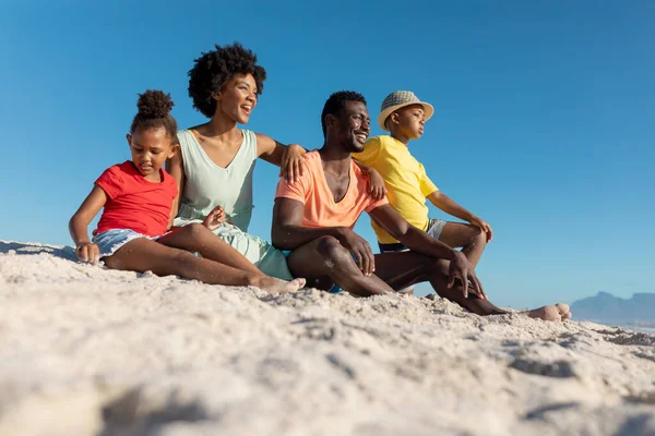 アフリカ系アメリカ人の家族の表面レベルのビューは 澄んだ青い空に対してビーチで砂の上に座っている 変わることのない家族生活一緒に楽しむ休日の概念 — ストック写真