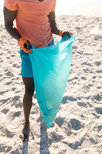 Нижняя Часть Африканского Американца Держит Синий Пластиковый Пакет Собирая Мусор — стоковое фото