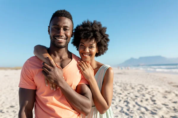 晴れた日にビーチで彼氏を抱きしめるアフリカ系アメリカ人女性の笑顔の肖像画 変わらないライフスタイル愛団結休日の概念 — ストック写真