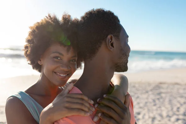 Muotokuva Hymyilevä Afrikkalainen Amerikkalainen Nainen Halaa Poikaystävä Takaapäin Rannalla Aurinkoisena — kuvapankkivalokuva