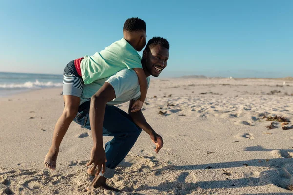 Χαρούμενος Αφροαμερικάνος Που Δίνει Την Πλάτη Του Στο Γιο Του — Φωτογραφία Αρχείου