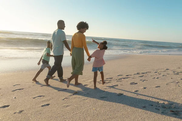 在阳光明媚的日子里 非裔美国人父母和孩子们手牵着手在海滩上散步 不变的家庭 生活方式 享乐及假日概念 — 图库照片