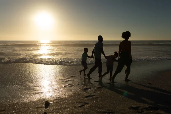 Pełna Długość Afrykańskiej Rodziny Trzymającej Się Ręce Spacerujące Plaży Zachodzie — Zdjęcie stockowe