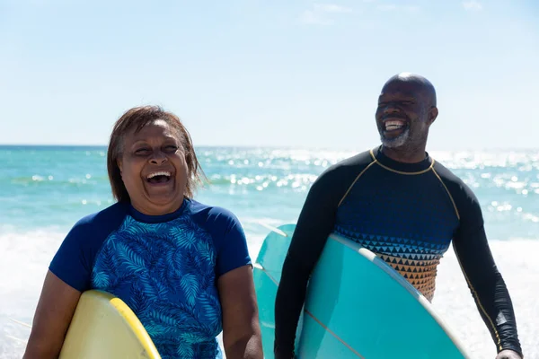 快乐的非洲裔美国老年夫妇 背着冲浪板 在海滩享受着阳光灿烂的日子 积极的生活方式 水上运动及度假概念 — 图库照片