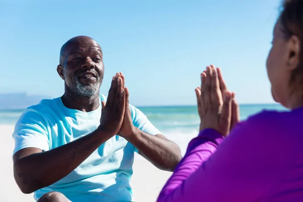 非裔美国老年男女手牵着手在海滩上练习瑜伽 不变的 健康和积极的生活方式概念 — 图库照片