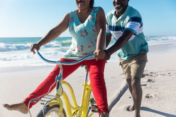 African American Senior Man Assisting Woman Riding Bicycle Beach Sunny — Stock Photo, Image