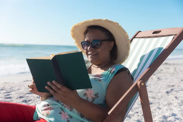 Afro Americana Jubilada Mujer Mayor Lectura Libro Mientras Sentado Silla —  Fotos de Stock