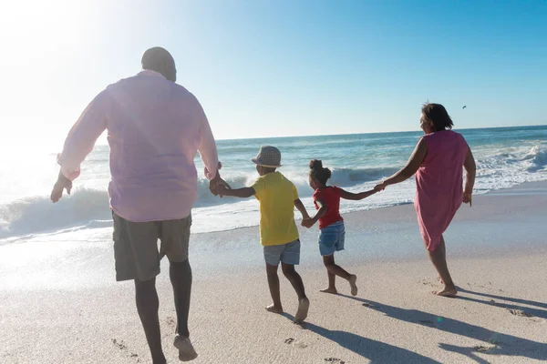 アフリカ系アメリカ人の祖父母と孫たちが海岸を歩いている 変わることのない家族生活一緒に楽しむ休日の概念 — ストック写真