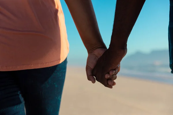ビーチで手をつないでいるアフリカ系アメリカ人のシニアカップルの中央部 変わらない愛 ライフスタイル 楽しみと休日のコンセプト — ストック写真