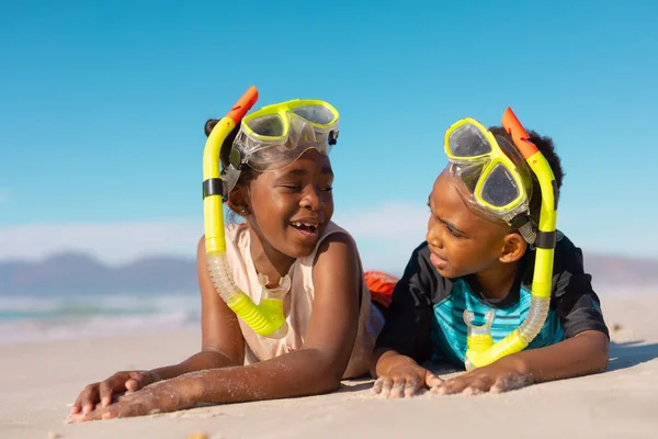 アフリカ系アメリカ人の男の子と女の子は シュノーケリングやマスクを着て 砂の上に横たわって空に向かって話しています コピースペース 変更なし ビーチ 子供時代 一緒に 楽しみ — ストック写真