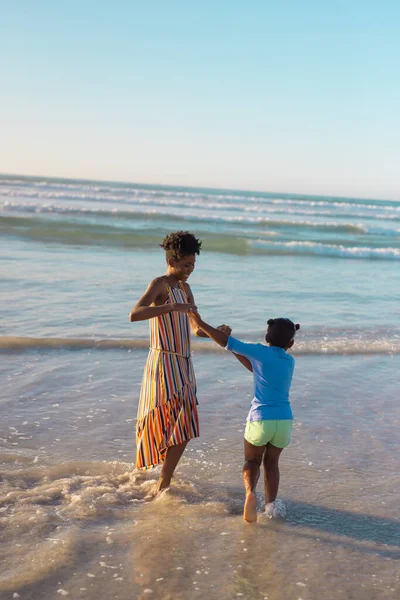 Alegre Madre Joven Afroamericana Sosteniendo Las Manos Niña Disfrutando Mar — Foto de Stock