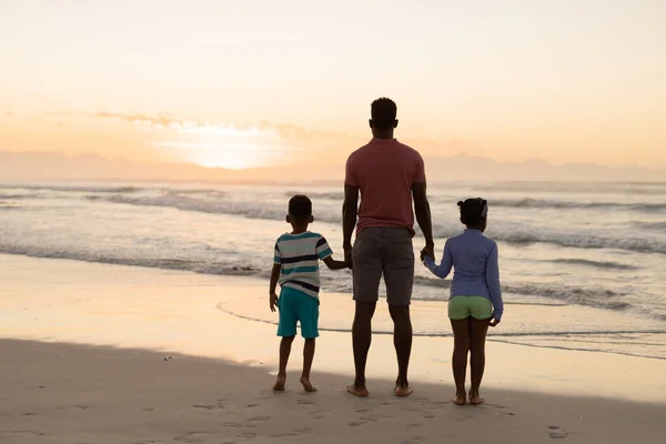 日没の間に空に対して海を見て息子と娘とアフリカ系アメリカ人の父の後部ビュー 変わらないビーチ 子供時代 ライフスタイル 楽しみそして休日 — ストック写真