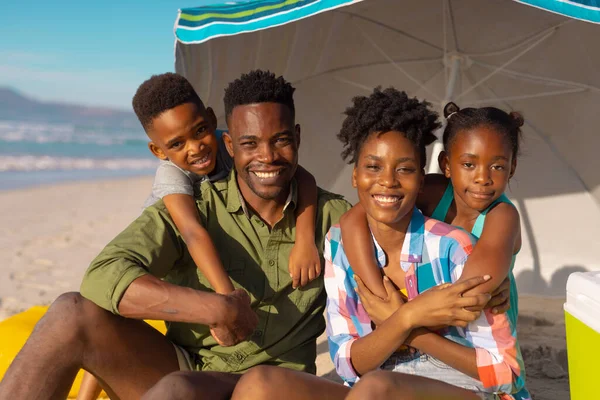 Портрет Счастливых Африканских Молодых Родителей Мальчиком Девочкой Сидящих Зонтиком Пляже — стоковое фото