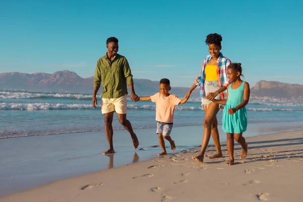 幸せなアフリカ系アメリカ人の若い両親が子供の手を取り 澄んだ空に向かってビーチを歩く コピースペース 変わらない 子供時代 一緒に ライフスタイル 楽しみ — ストック写真