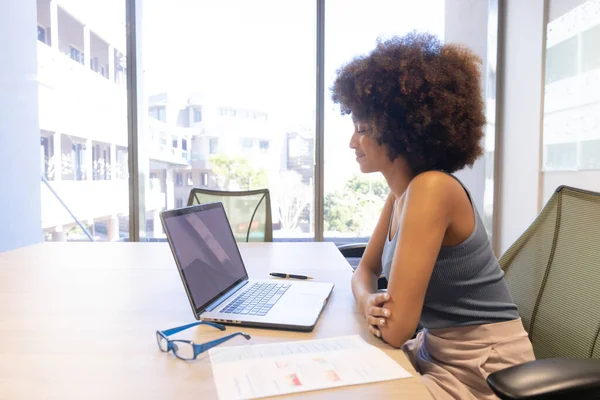 在现代工作场所 一个年轻的 手握笔记本电脑的惊慌失措的女商人坐在办公桌前的侧视图 商业和现代办公概念 — 图库照片