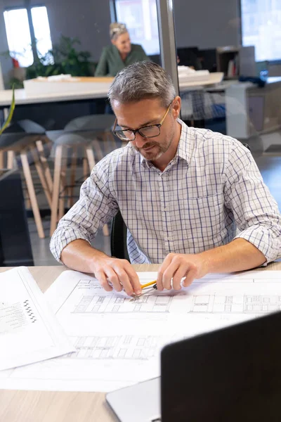 自信的高加索男性工程师在现代工作场所的写字台上绘制蓝图 富有创意的商业和现代办公理念 — 图库照片